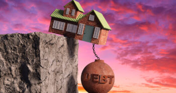 House lodged in a very precarious way, hanging over cliff and being pull down by a metallic ball marked with debt. Illustration of the concept of mortgage and overspending debt