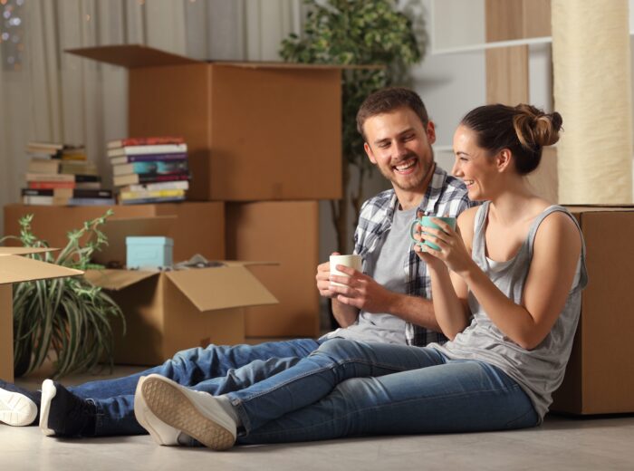 Happy couple moving home resting and talking