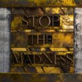 Stop The Madness text formed with real authentic typeset letters on vintage textured silver grunge copper and gold background